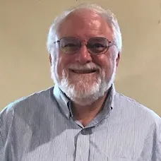 a man with glasses smiling