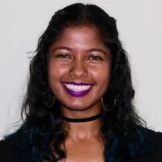 a woman with dark hair and purple lipstick smiling