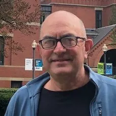 a man wearing glasses and a blue jacket