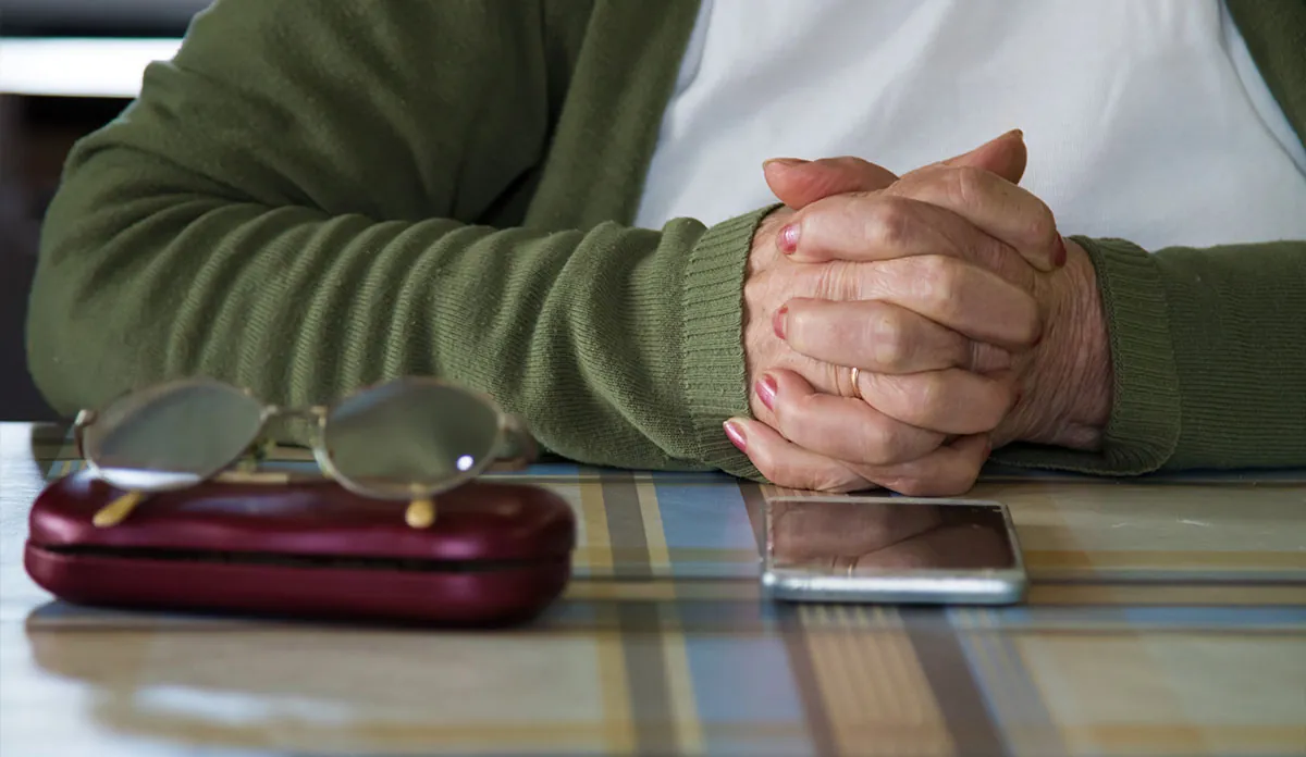 a person's hands folded on a table