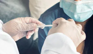 a person holding a tube with a needle