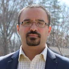 a man with a goatee and glasses