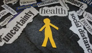 a yellow paper cut out of a person surrounded by newspaper headlines