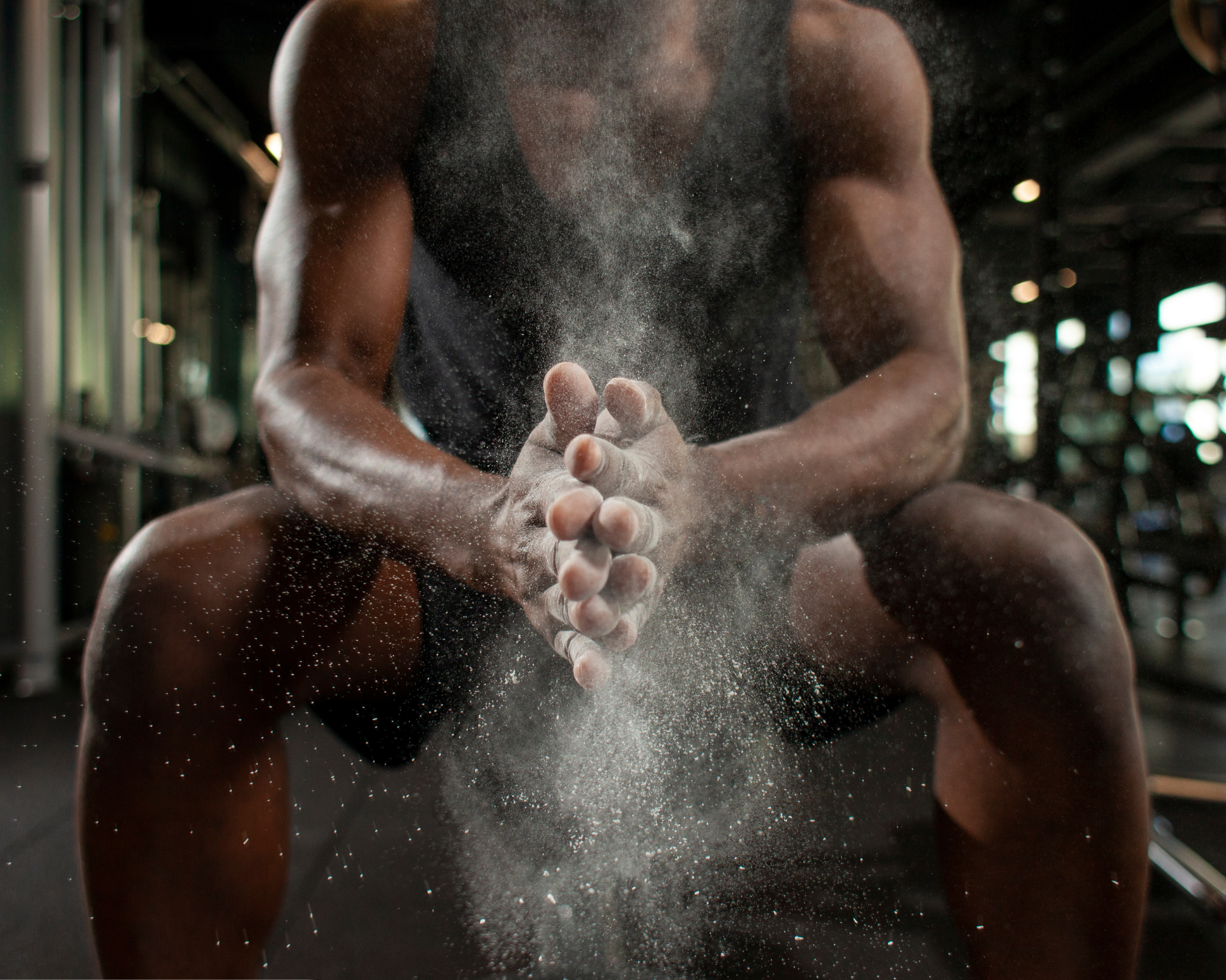 Close-up portrait of a young guy clapping his hands together in the fitness room. Athlete concept