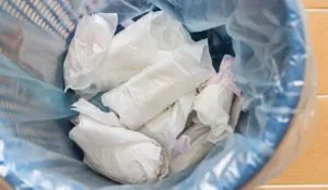 a trash can full of white paper towels