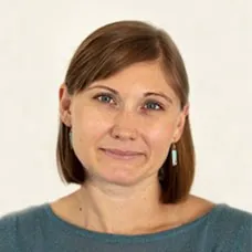 a woman with short brown hair wearing a blue shirt