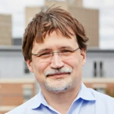 a man wearing glasses and a blue shirt