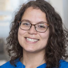 a woman wearing glasses and a blue shirt