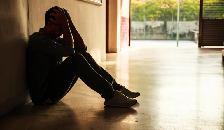 a man sitting on the floor with his hands in his head