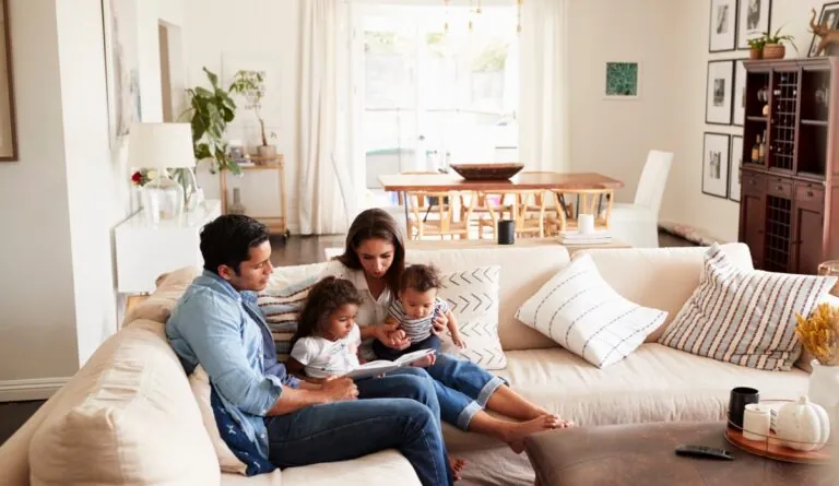 a family sitting on a couch reading a book