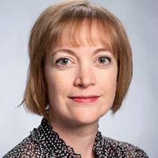 a woman with short hair wearing a polka dot shirt