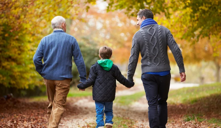 a group of men holding hands and walking on a path
