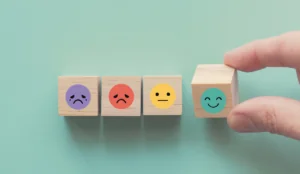 a hand holding a block with emojis on it