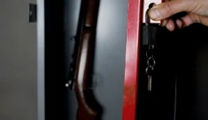 a hand holding a key and a gun