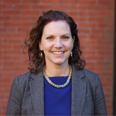 a woman wearing a suit and a necklace
