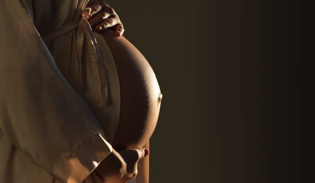 close up image of pregnant woman's growing baby bump