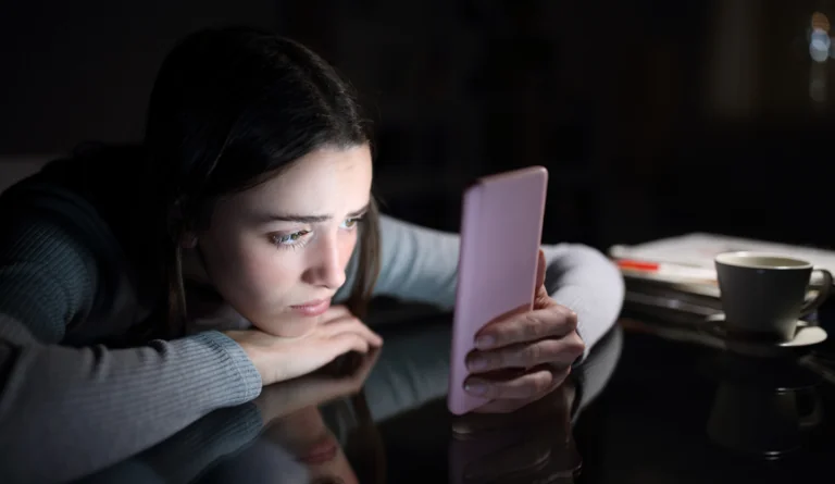 young, depressed girl scrolling through TikTok on her phone