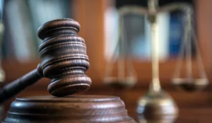Law and Justice concept. Close up of judge's mallet, with books and scales of justice in the background