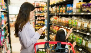 young girl pointing at unhealthy food products at the grocery store