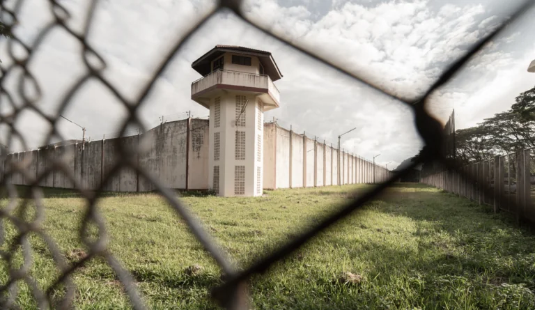 Looking through fence at the outside of a prison