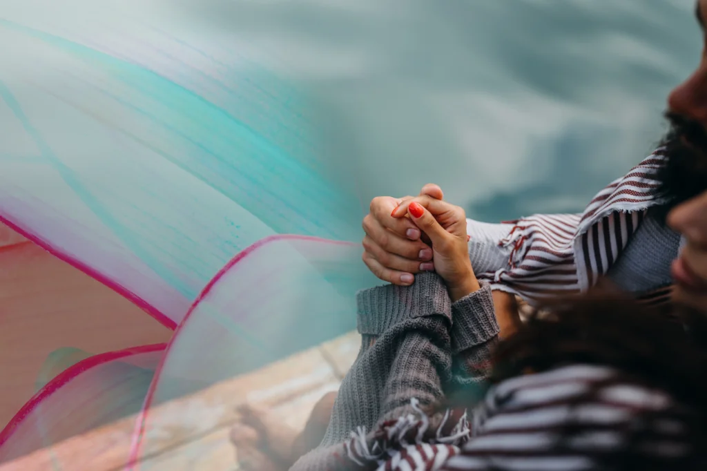 a person holding hands with a red nail polish