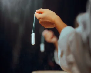 hand of young woman holding a tampon