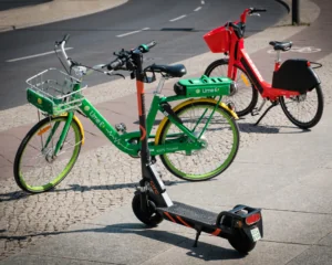 Rentable e-bikes and electric scooters parked on the sidewalk