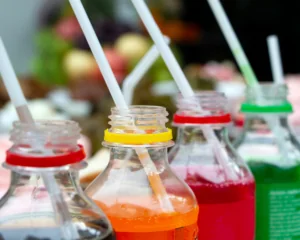 assorted sweetened beverage bottles with plastic straws