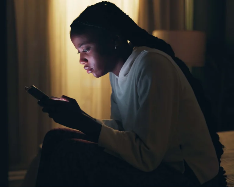 Portrait of a young woman, alone and scrolling on her phone