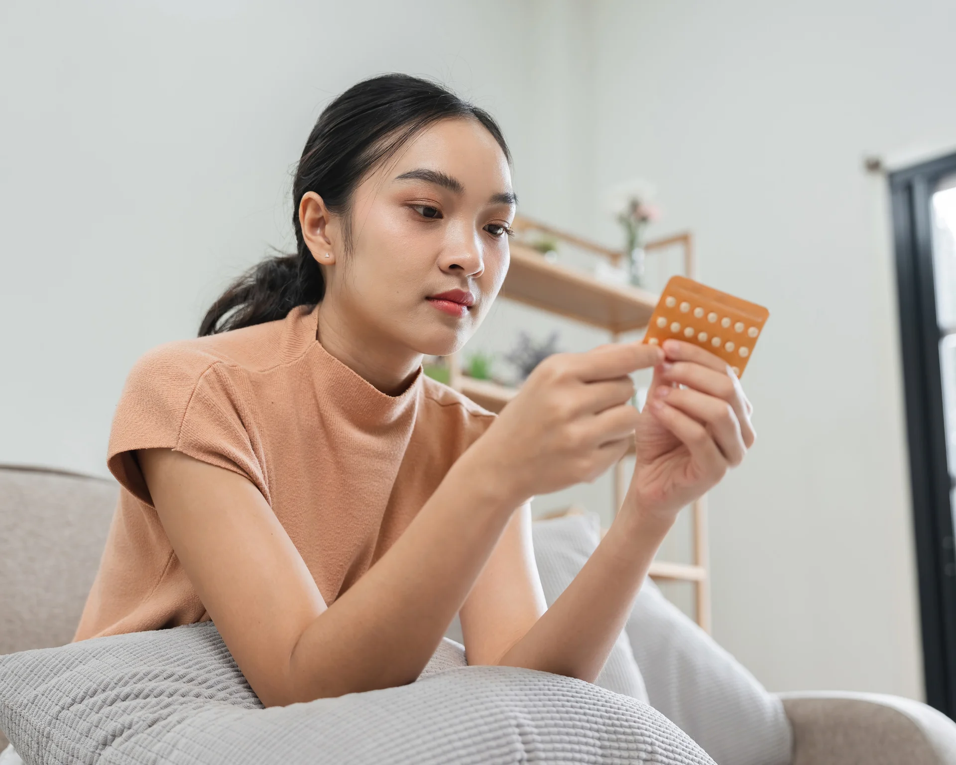 Young woman taking birth control pills, emphasizing contraceptive health concept