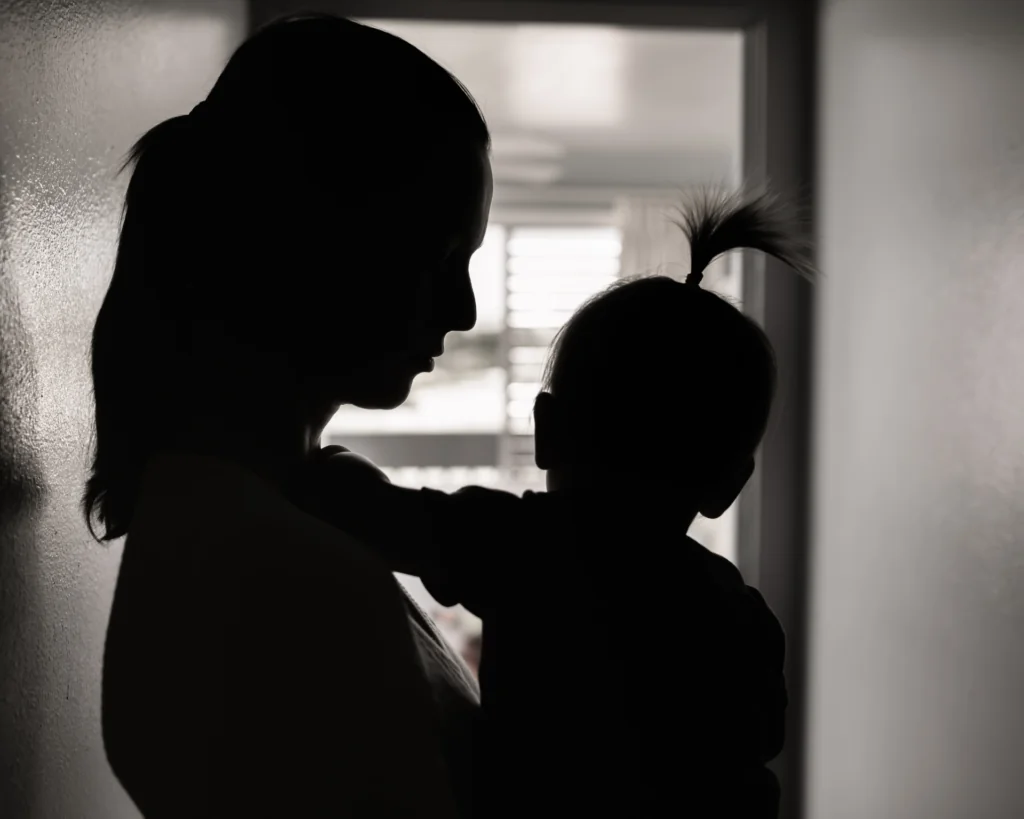 silhouette of a stressed mother taking care of her young child