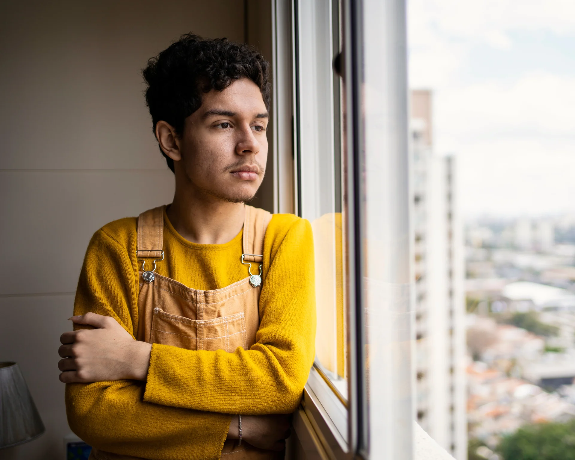 Portrait of a young man looking out a window