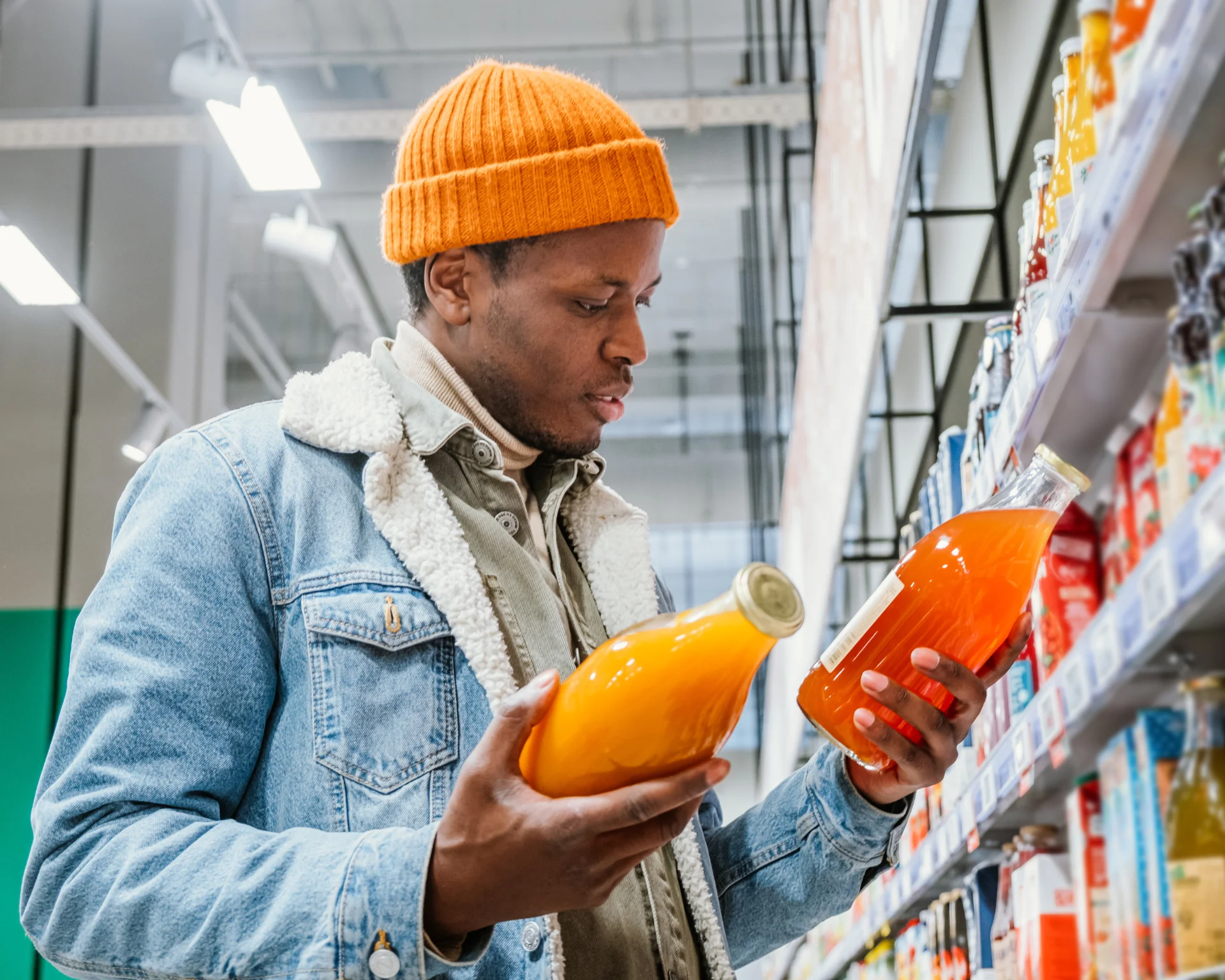 portrait of a young Black man looking at beverage products while grocery shopping