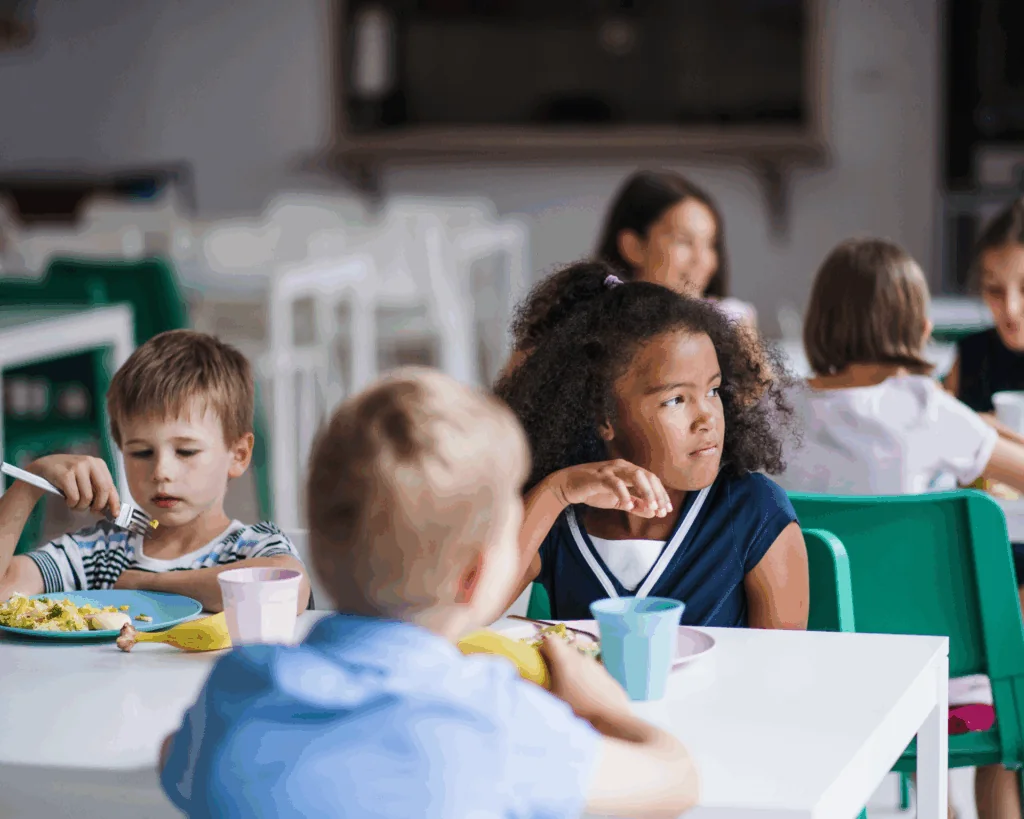 Group of young kids eating lunch in school cafeteria
