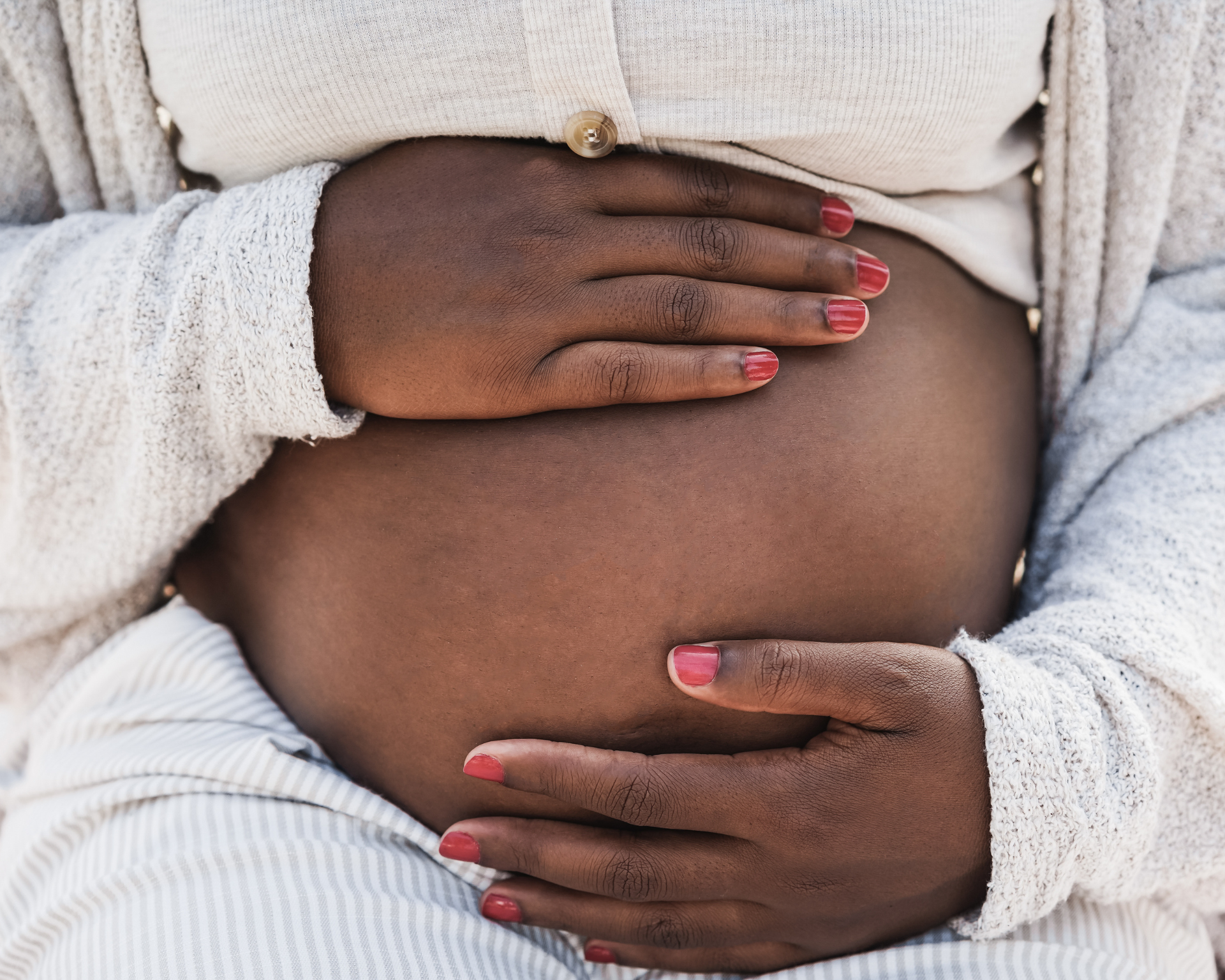 Close up of Black woman holding her pregnant belly