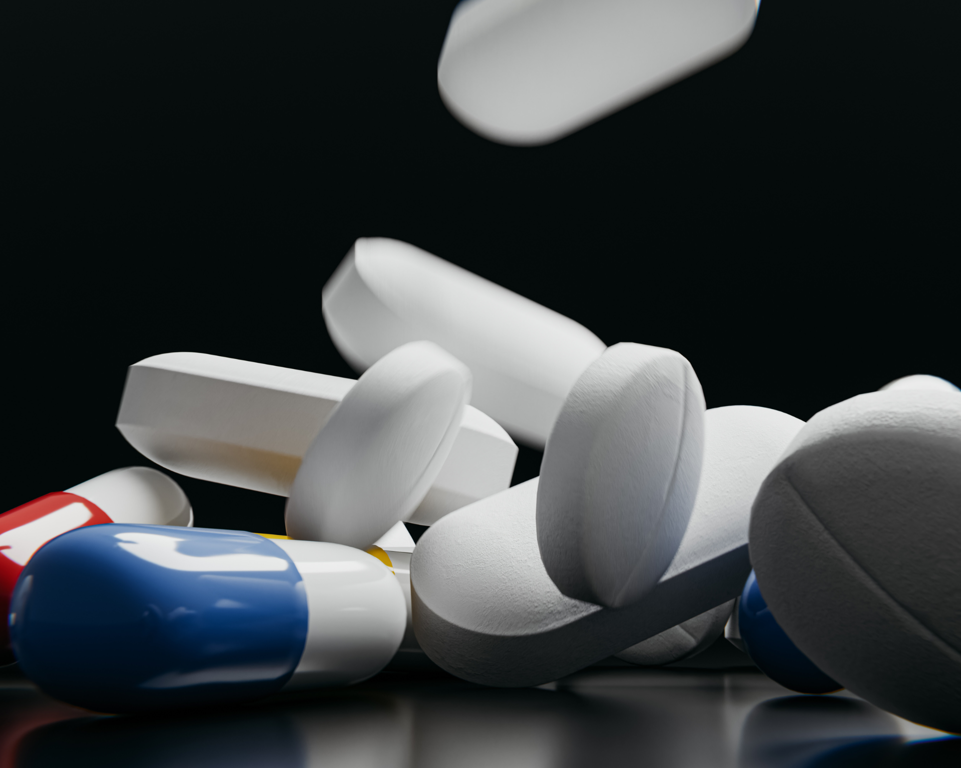Close up photo of pills falling and piling up on a black background. Opioid crisis concept