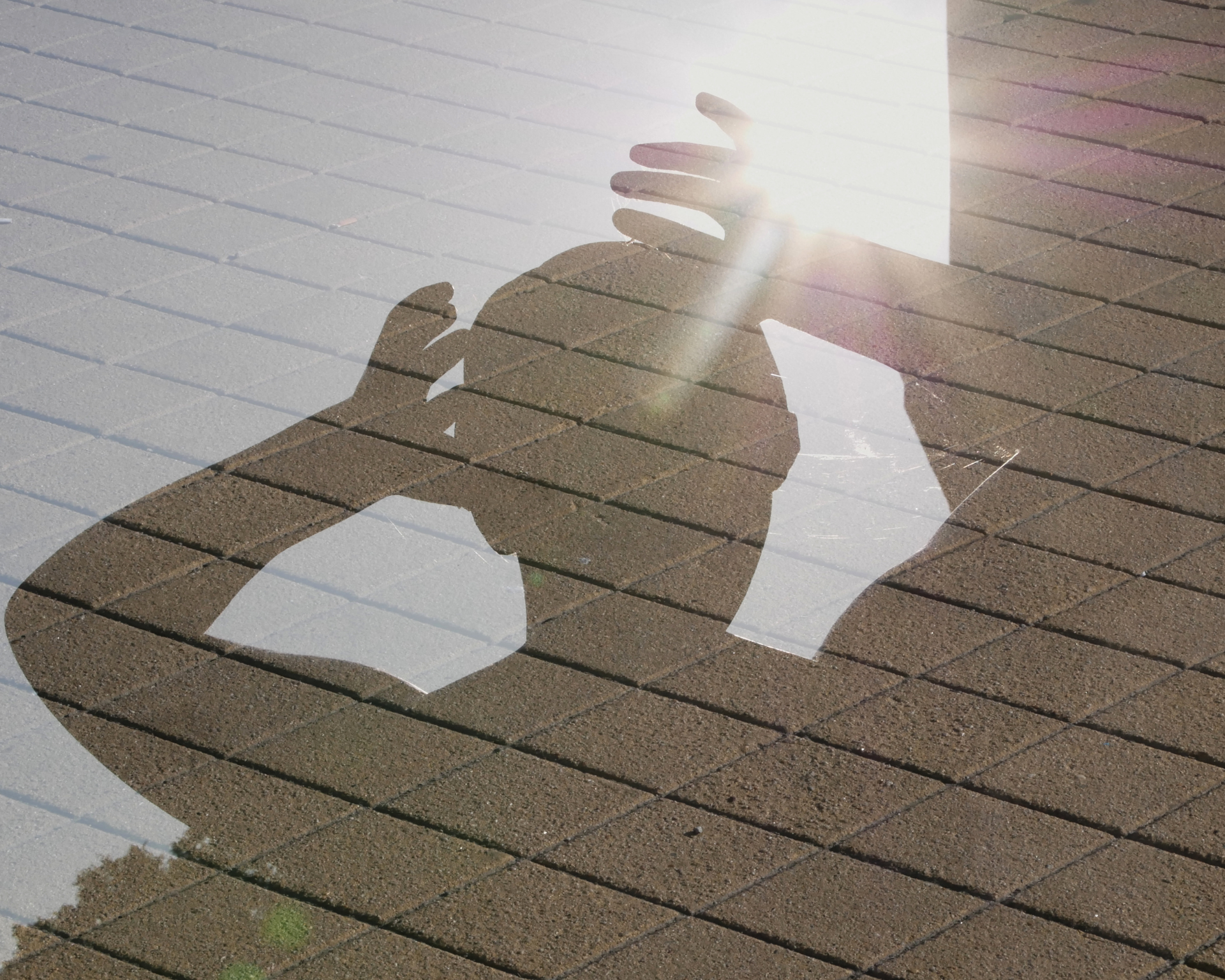 Double exposure of a person looking into the sun trying to cover the sun beam in hot summer weather
