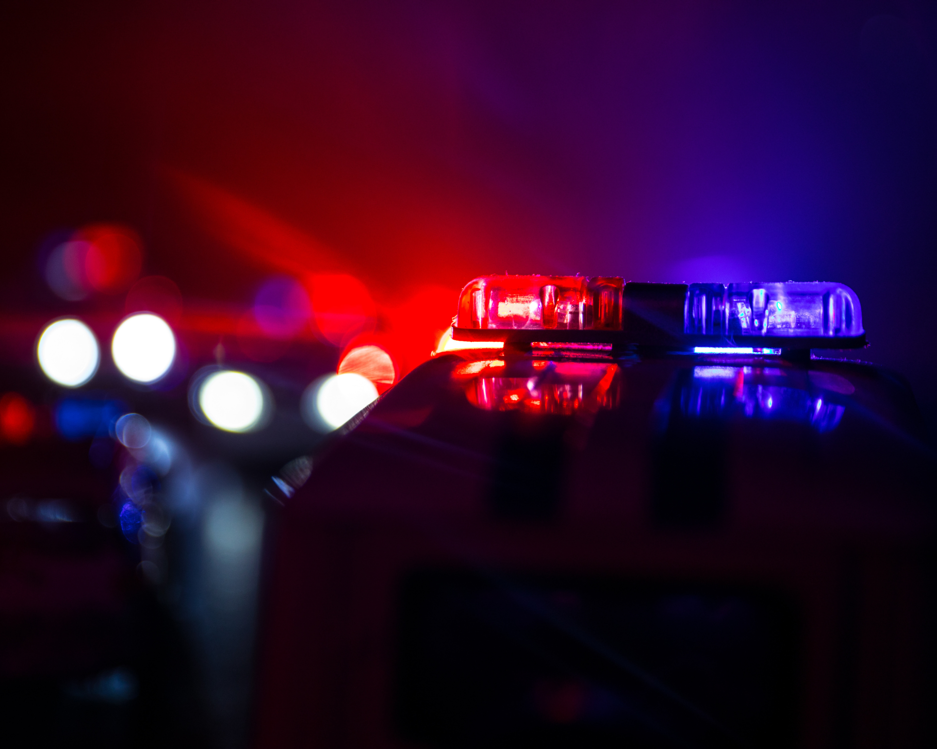Police car chasing a car at night with a foggy background