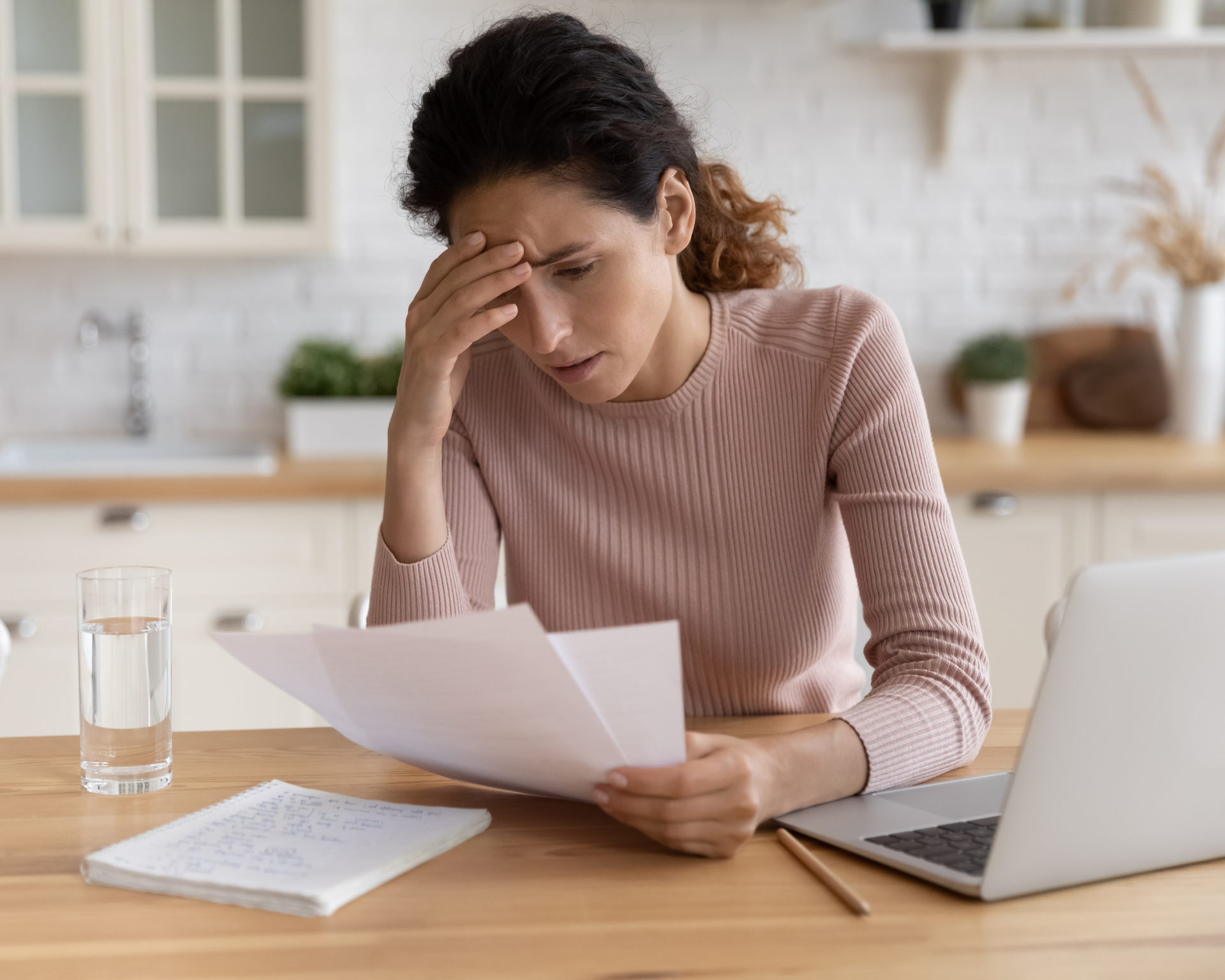 Worried, stressed young woman looking at health insurance bills