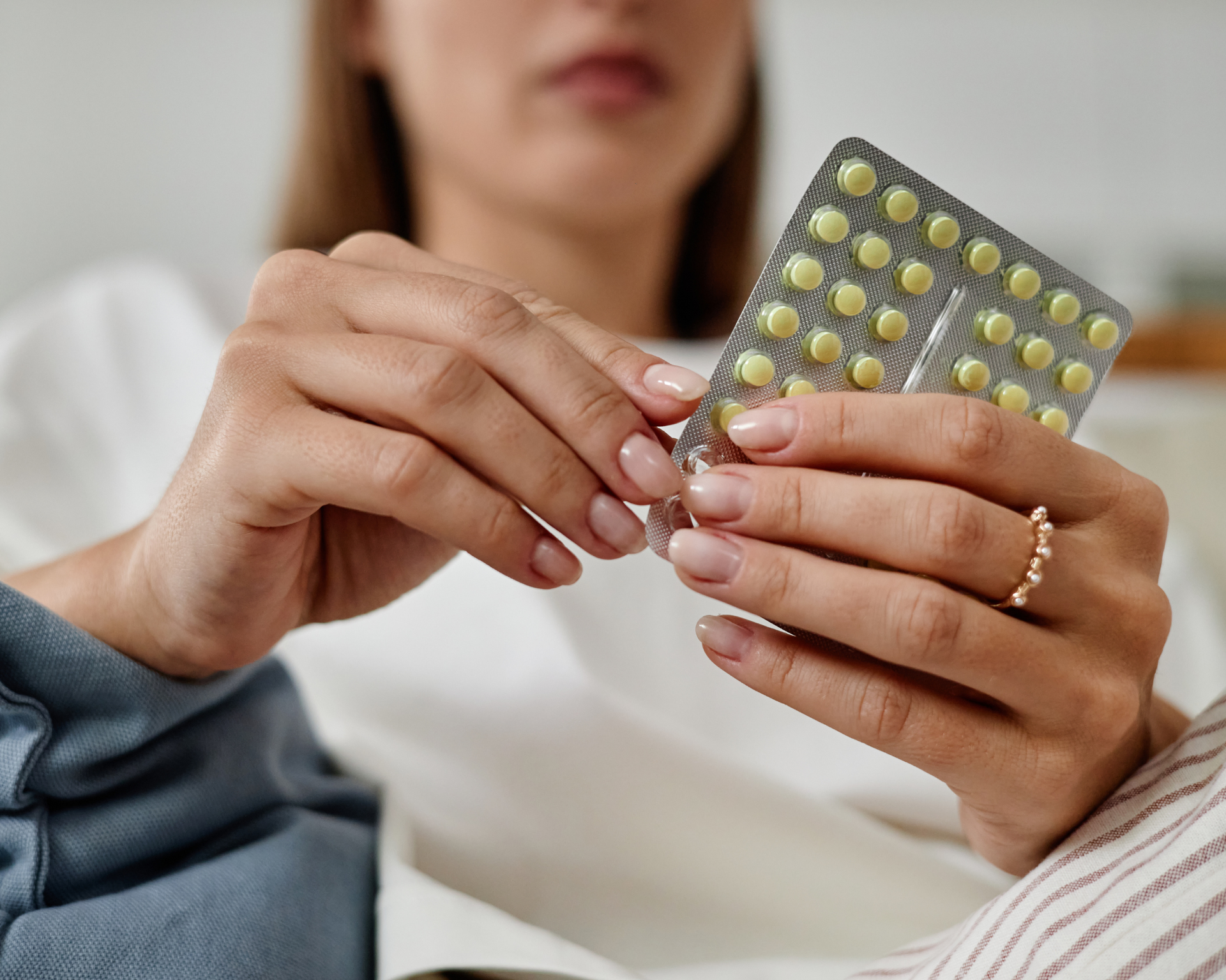 Young Woman Holding Blister Pack of Oral Contraceptive Pills