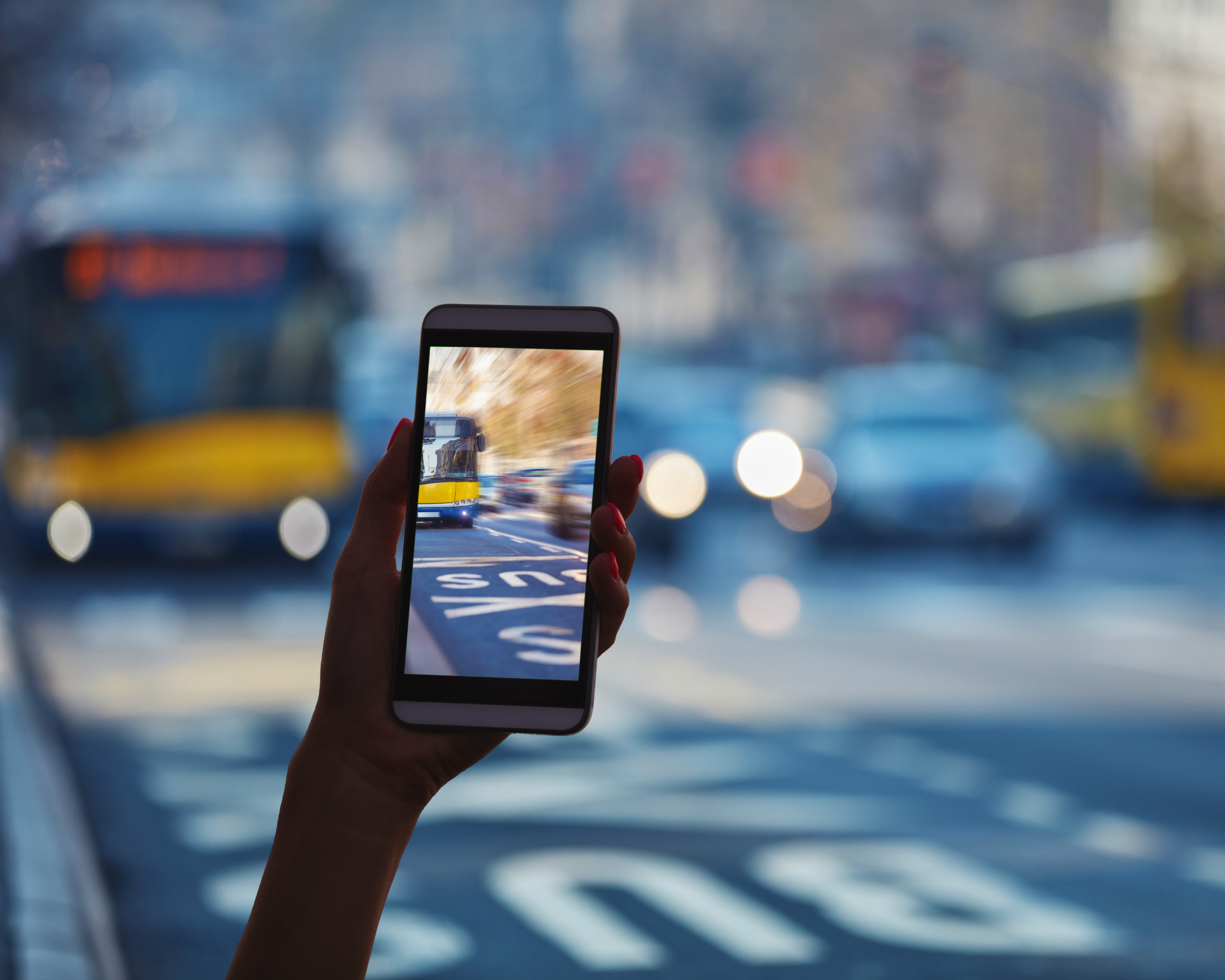 Person holding phone and taking photo of bus lane while walking across the street. Community-led solutions and AI use concept