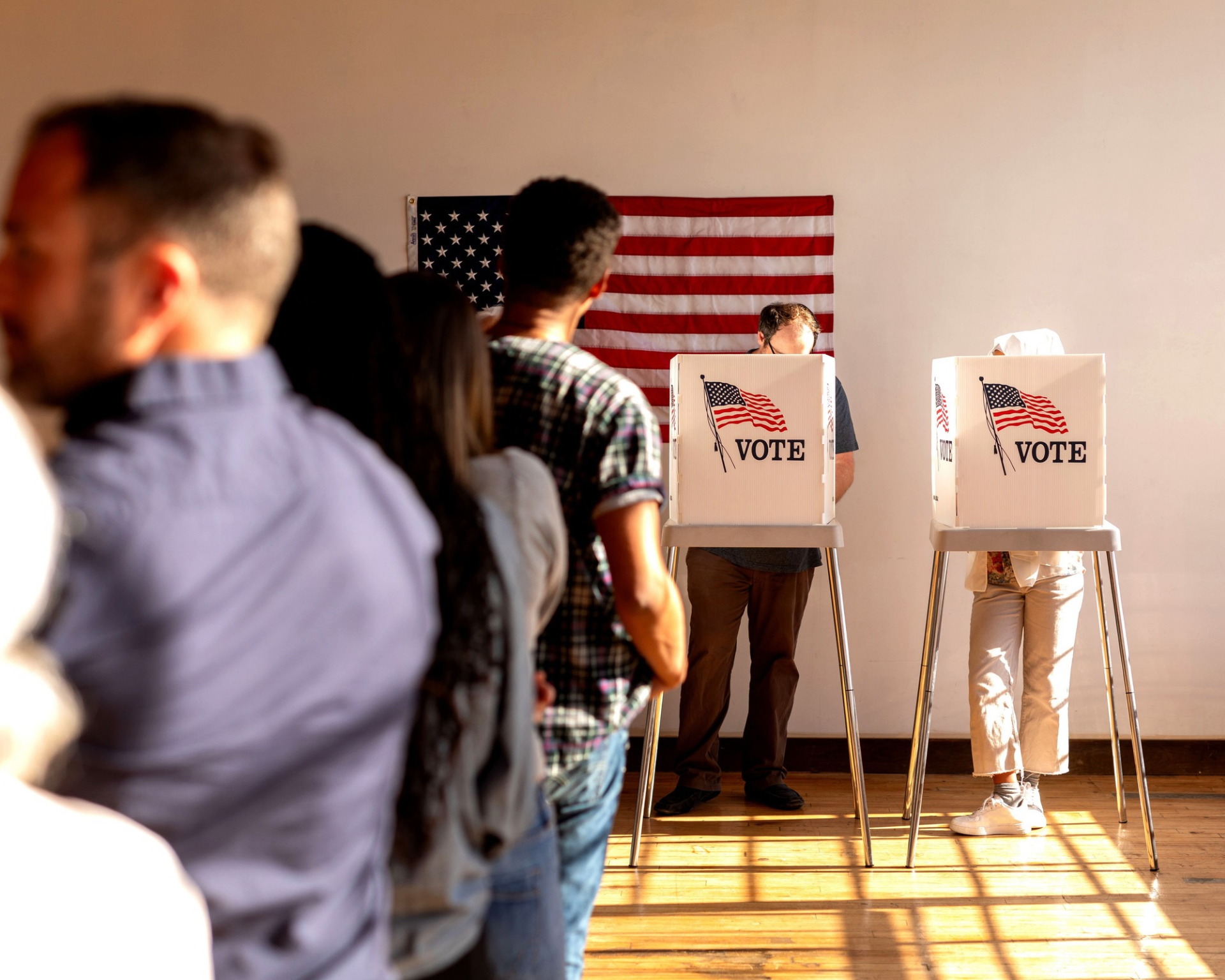 Voting booth with American flag on back wall. Midterm election concept